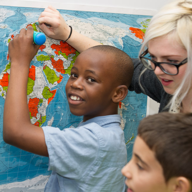 Listen to the World In this photograph, a young boy of African decent is stood in front of a map of the world, holding a turquoise PENpal, a talking pen device developed by Mantra Lingua that enables him to listen to and add sound to books, drawings and other objects.